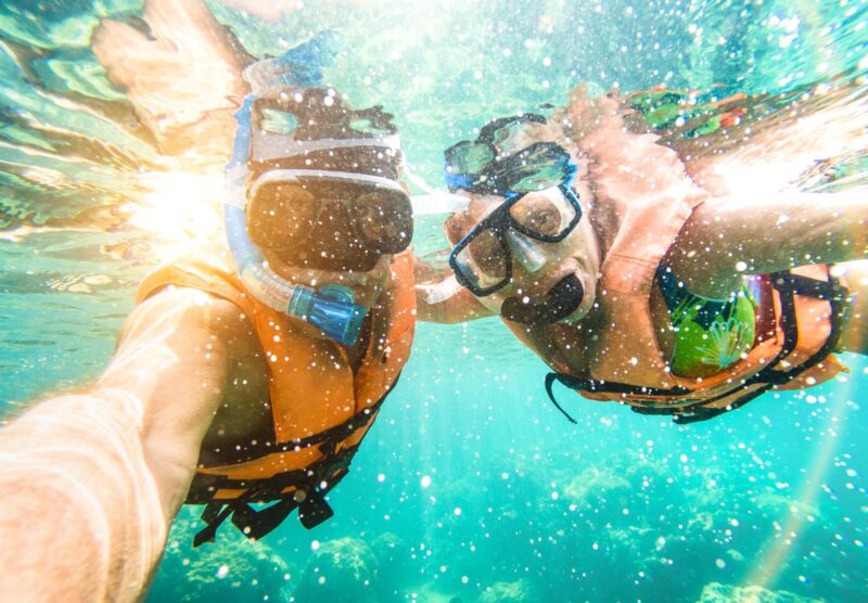two people taking an underwater snorkeling selfie