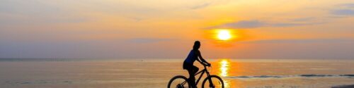 woman biking at sunset