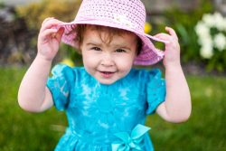 little girl holding her hat