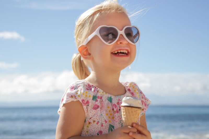 Little girl enjoying an ice cream cone on the beach